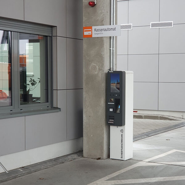 Ausfahrfahrtstraße Werkstoffhof mit Kassenautomat an einer Säule an der ein Schild mit Aufdruck Kassenautomat angebracht ist.