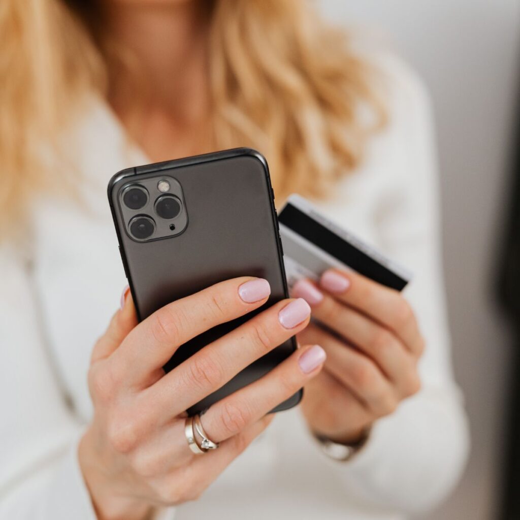 Paymentlösung HKSpay. Frau mit Karte und Handy